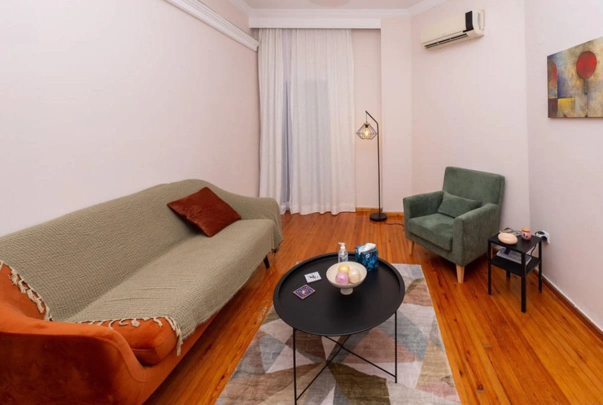 Living room with white sofa, wooden desk and abstract wall art
